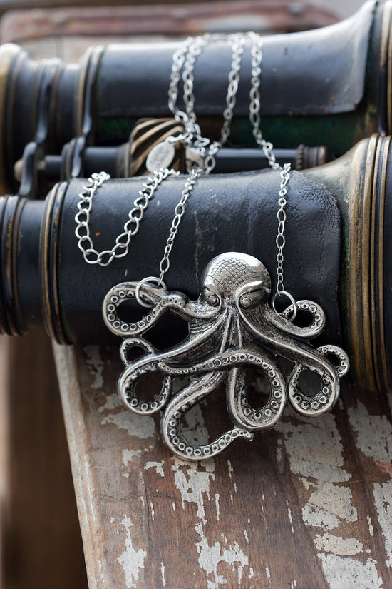 Silver octopus pendant necklace on vintage binoculars 