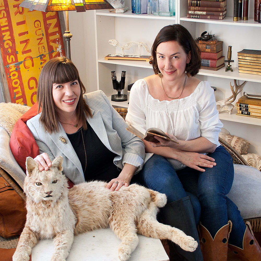 Seana and Tara posing with stuffed wildcat in living room